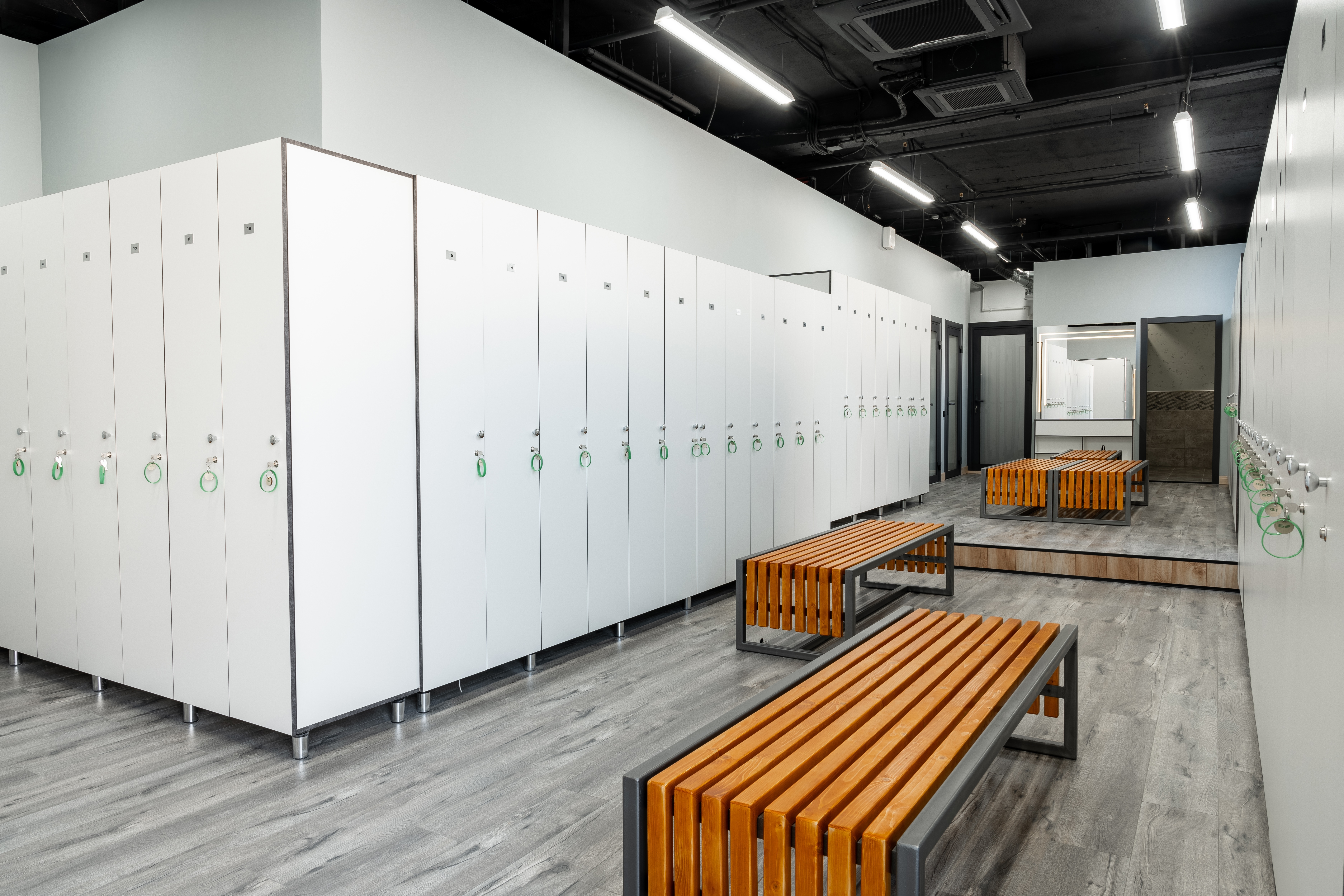 Rows of lockers and wooden benches in a newly renovated changing room.